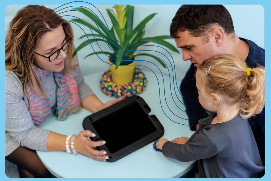 A teacher showing a young child and a parent a tablet